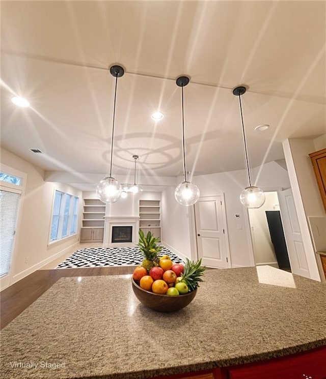 1147 Halletts Peak Pl, Lawrenceville, GA 30044 - kitchen with open floor plan, dark stone countertops, wood finished floors, a fireplace, and decorative light fixtures