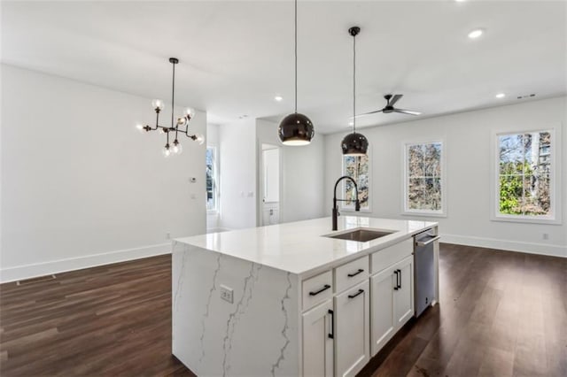 kitchen with dark wood-type flooring, ceiling fan with notable chandelier, a sink, baseboards, and dishwasher