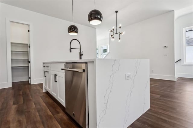 kitchen featuring decorative light fixtures, an island with sink, dark wood-style floors, white cabinets, and a sink