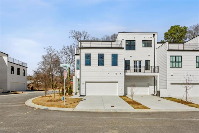 view of front facade featuring a balcony, concrete driveway, and an attached garage