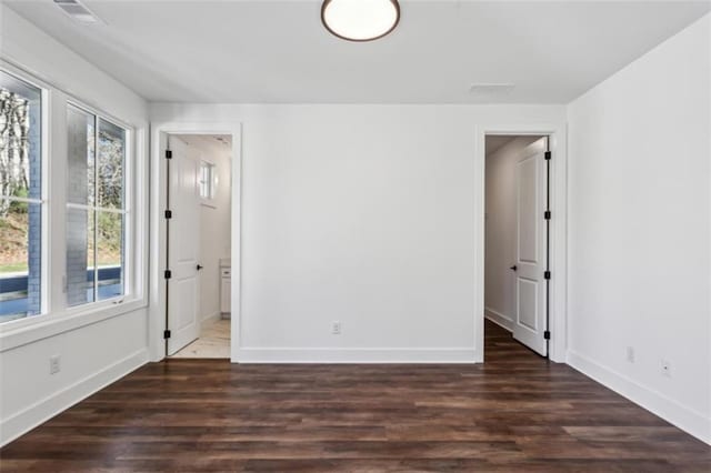 unfurnished room with visible vents, baseboards, and wood finished floors