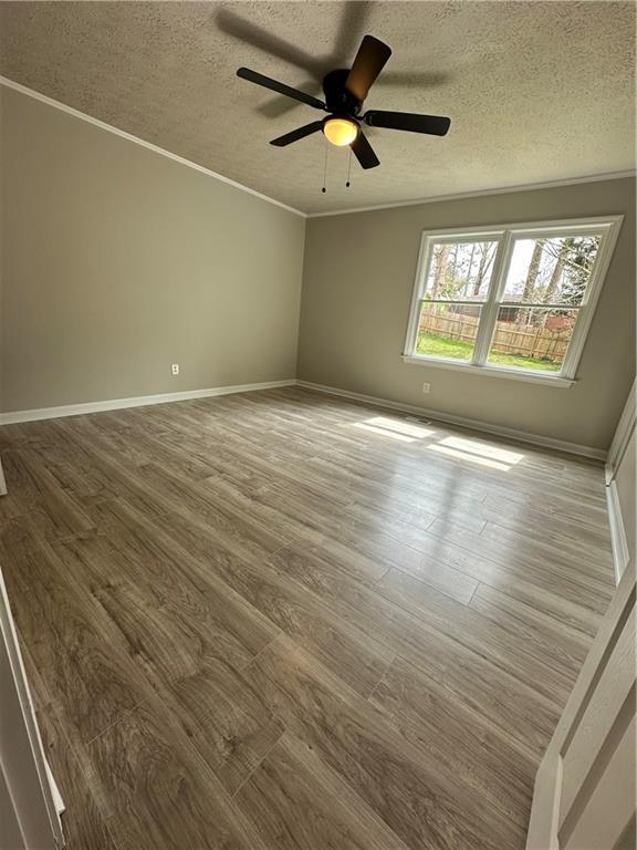 3967 Evelyn Dr, Powder Springs, GA 30127 - empty room featuring a textured ceiling, wood finished floors, and crown molding