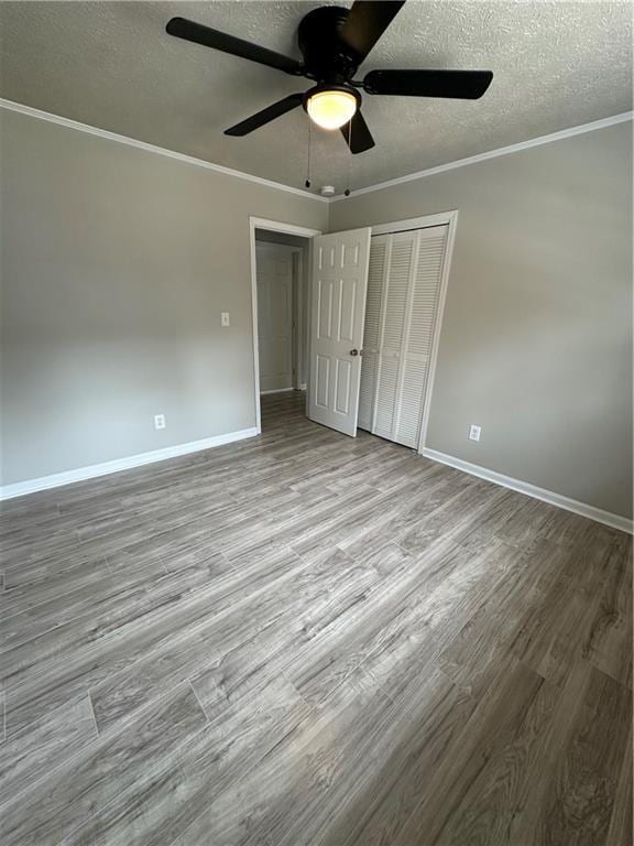 3967 Evelyn Dr, Powder Springs, GA 30127 - unfurnished bedroom with wood finished floors, baseboards, a closet, a textured ceiling, and crown molding