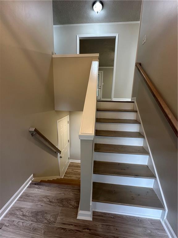 3967 Evelyn Dr, Powder Springs, GA 30127 - staircase featuring wood finished floors, baseboards, and a textured ceiling