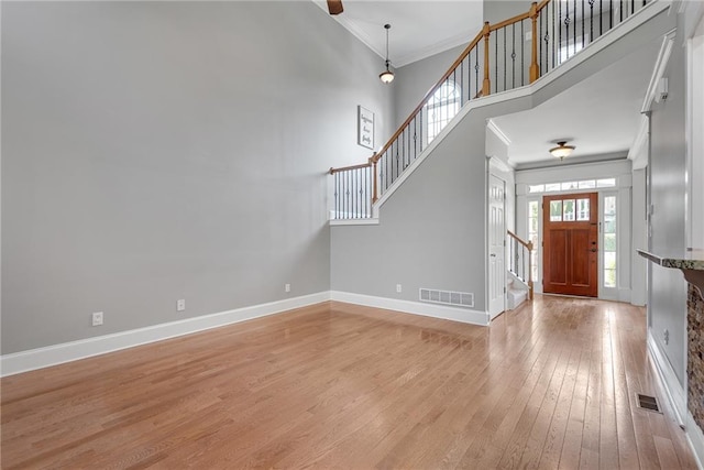 3085 Woodbridge Ln, Canton, GA 30114 - entryway featuring stairs, crown molding, light wood-style floors, a towering ceiling, and baseboards
