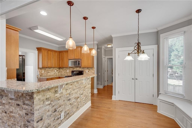 3085 Woodbridge Ln, Canton, GA 30114 - kitchen featuring stainless steel microwave, black range, tasteful backsplash, freestanding refrigerator, and light wood-style flooring
