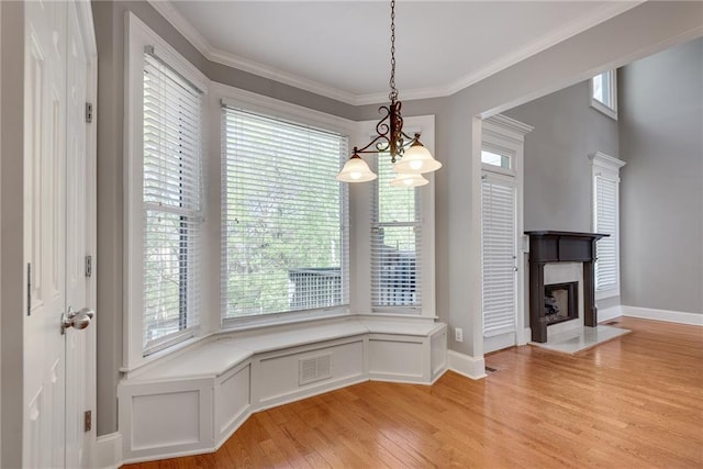 3085 Woodbridge Ln, Canton, GA 30114 - unfurnished dining area featuring light wood-style floors, baseboards, a chandelier, ornamental molding, and a high end fireplace