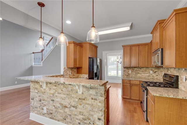 3085 Woodbridge Ln, Canton, GA 30114 - kitchen with stainless steel appliances, a peninsula, light stone counters, light wood finished floors, and crown molding