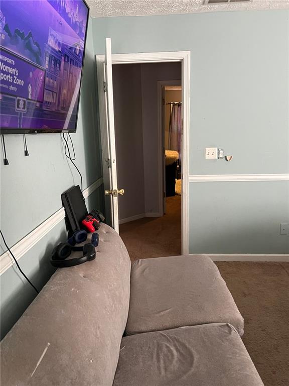 bedroom with a textured ceiling, carpet, and baseboards