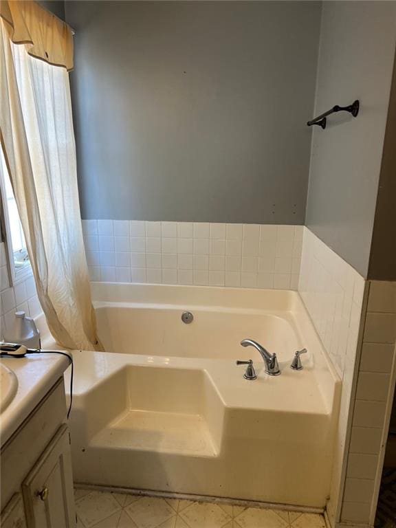 bathroom with a garden tub and vanity