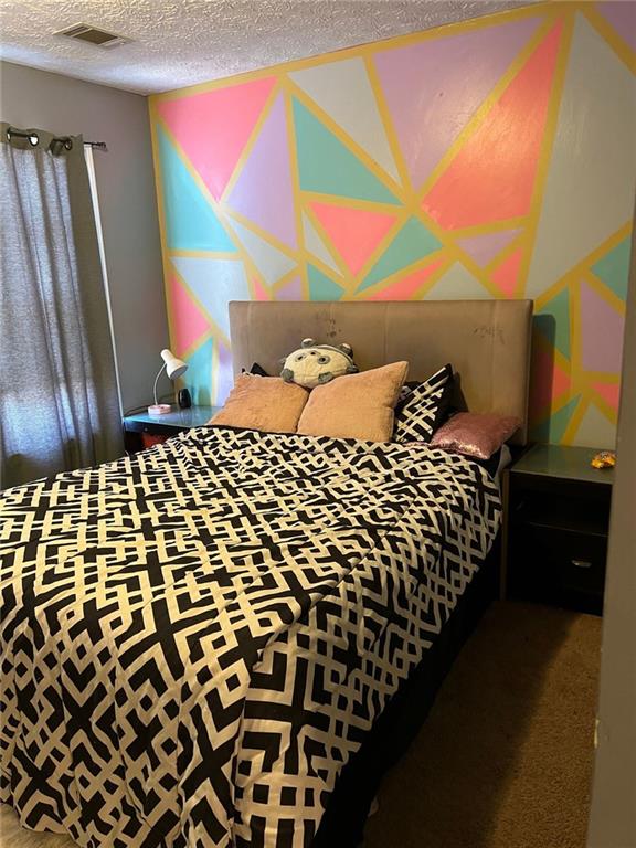 bedroom featuring visible vents and a textured ceiling