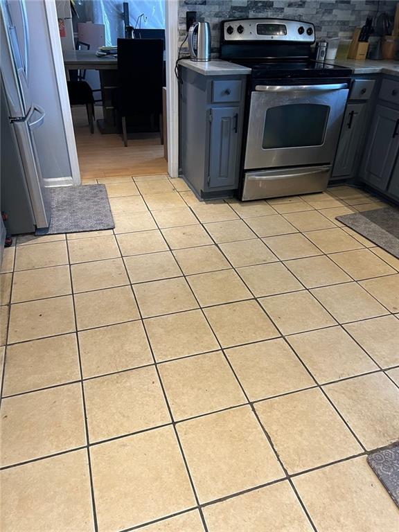 kitchen featuring appliances with stainless steel finishes, tasteful backsplash, and light tile patterned floors