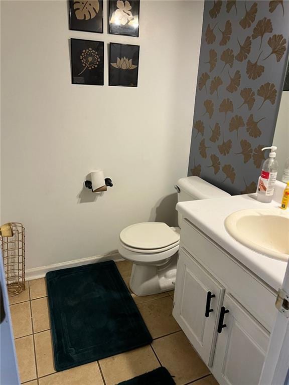 bathroom featuring toilet, tile patterned floors, baseboards, and vanity