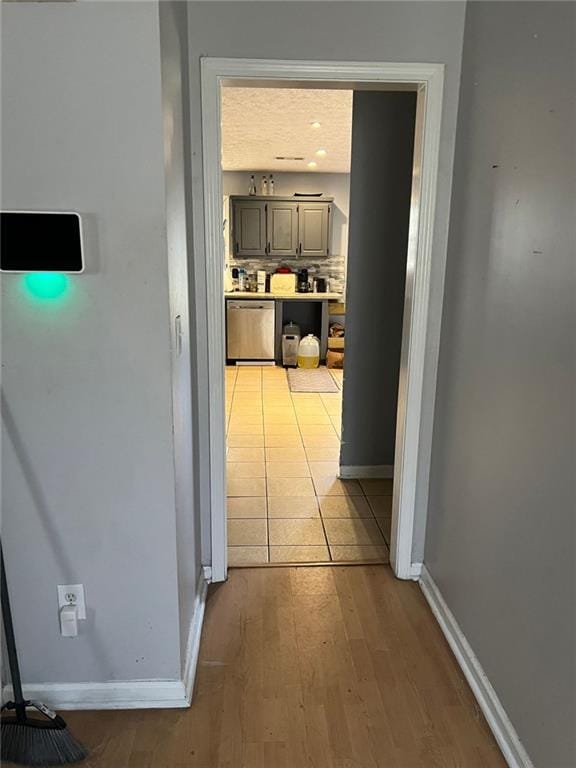 hallway featuring baseboards and light wood finished floors