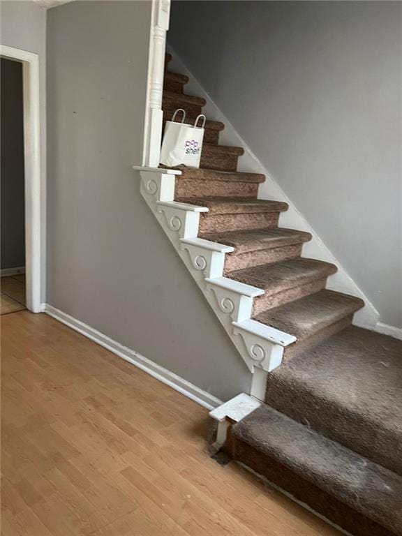 stairway with baseboards and wood finished floors