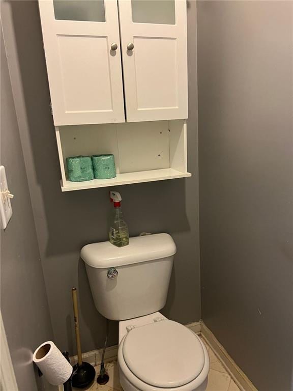 bathroom featuring tile patterned flooring, toilet, and baseboards