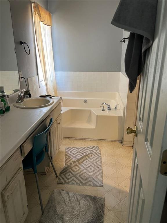 full bath with a garden tub, tile patterned flooring, and vanity