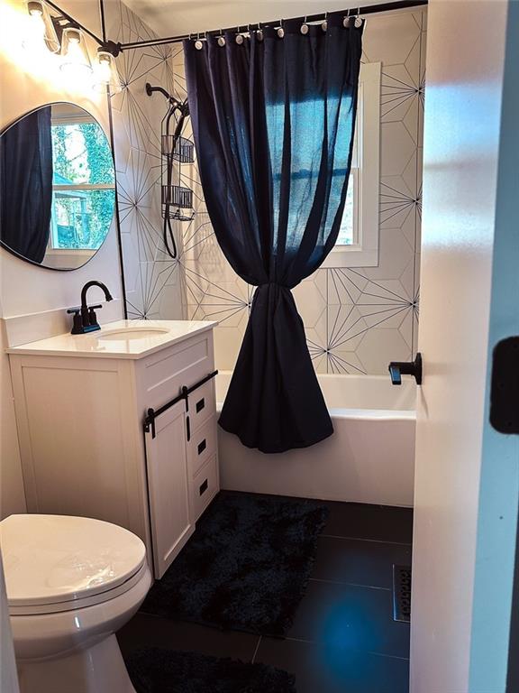 full bathroom featuring toilet, vanity, and shower / bathtub combination with curtain