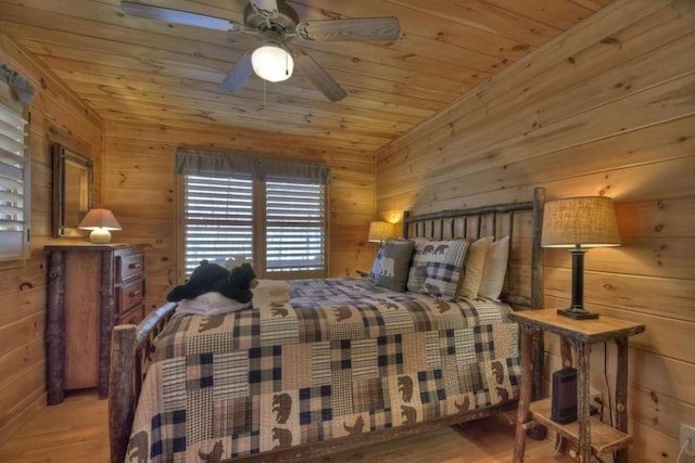 bedroom with wood ceiling, wooden walls, ceiling fan, and hardwood / wood-style flooring