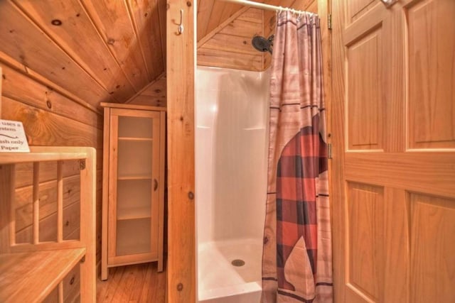 bathroom with lofted ceiling, a shower with curtain, hardwood / wood-style floors, and wood ceiling