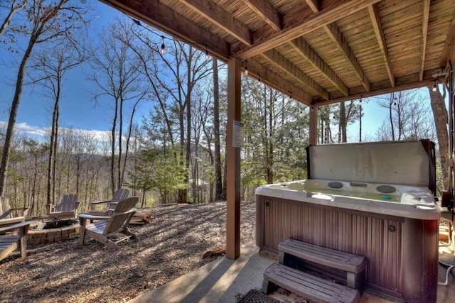 deck with a hot tub and an outdoor fire pit