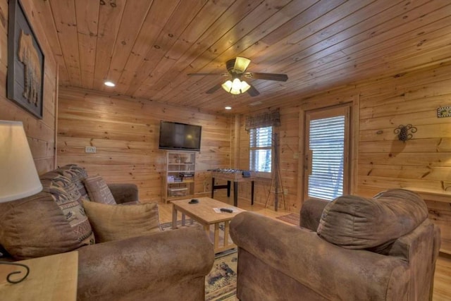 living room featuring wood walls, ceiling fan, wooden ceiling, and light wood-type flooring