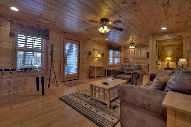 living room with wooden ceiling, a wealth of natural light, light hardwood / wood-style flooring, and wooden walls