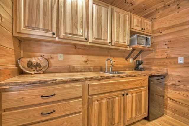 kitchen with light wood-type flooring, sink, wood ceiling, and wood walls