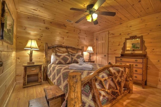 bedroom featuring wooden walls, light hardwood / wood-style floors, and wooden ceiling