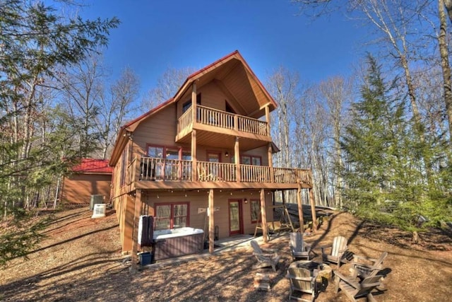 back of property featuring a balcony, a deck, and a patio