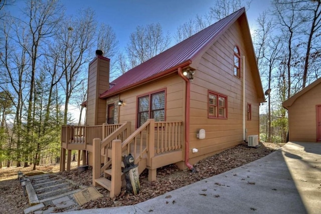 view of side of home with central air condition unit and a wooden deck