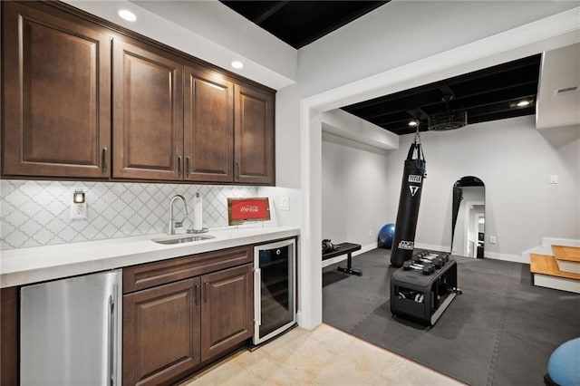 1235 Grand View Dr SE, Smyrna, GA 30126 - kitchen featuring wine cooler, stainless steel refrigerator, arched walkways, a sink, and light countertops