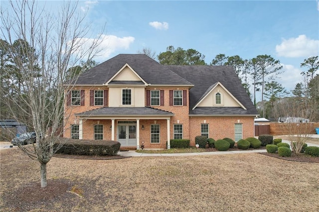 colonial home with a front yard and a porch