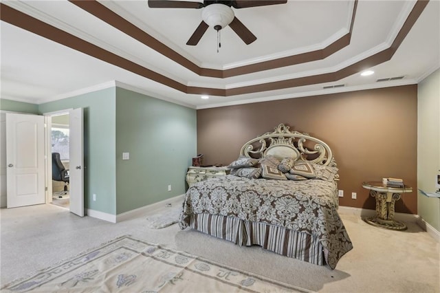 bedroom featuring a tray ceiling, carpet floors, ornamental molding, and ceiling fan