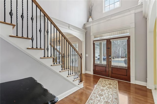 foyer entrance featuring a high ceiling, hardwood / wood-style floors, and french doors