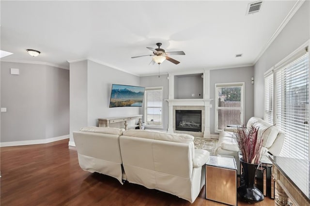 living room featuring hardwood / wood-style flooring, ceiling fan, ornamental molding, and a tile fireplace