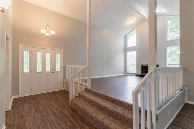 entryway featuring baseboards, a chandelier, high vaulted ceiling, and dark wood-style floors