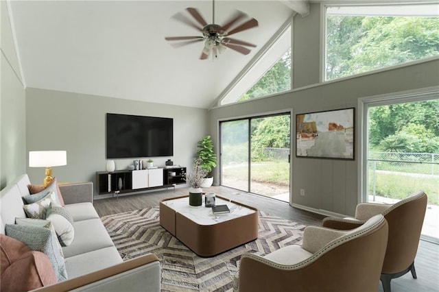 living area with wood finished floors, high vaulted ceiling, beam ceiling, a healthy amount of sunlight, and ceiling fan