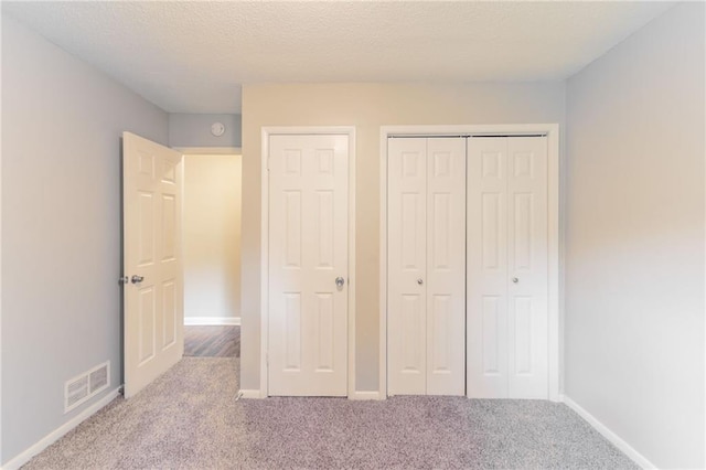 unfurnished bedroom featuring baseboards, a closet, visible vents, and carpet