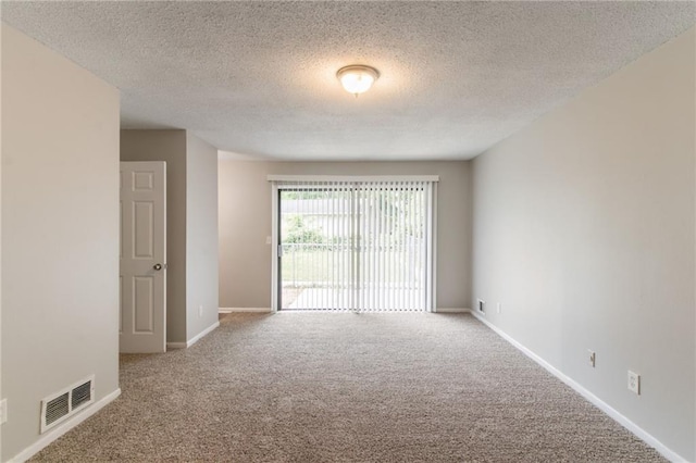 unfurnished room with baseboards, carpet flooring, visible vents, and a textured ceiling