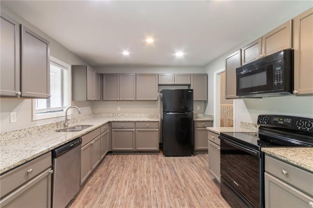 kitchen featuring a sink, black appliances, and gray cabinets
