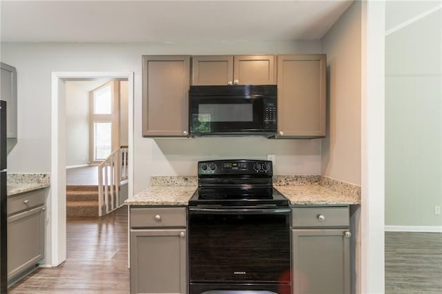 kitchen featuring light wood-style flooring, baseboards, black appliances, and gray cabinets