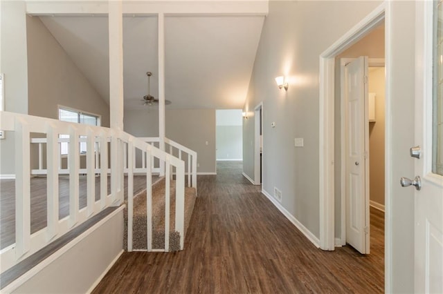 corridor featuring vaulted ceiling, baseboards, and wood finished floors