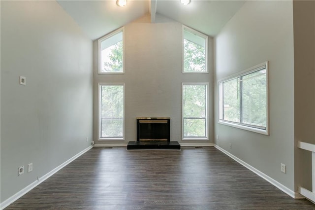 unfurnished living room featuring baseboards, high vaulted ceiling, and plenty of natural light