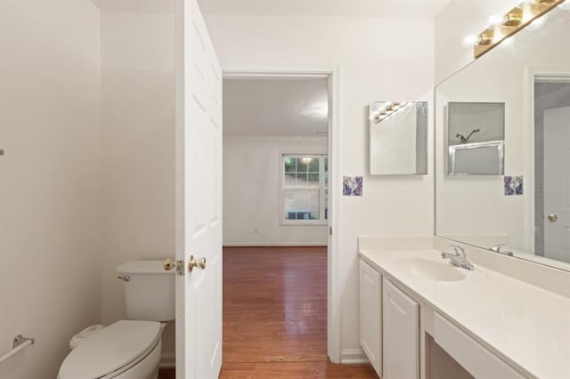 bathroom with hardwood / wood-style floors, vanity, and toilet