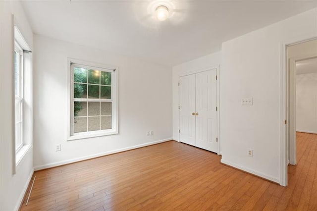 unfurnished bedroom with a closet and light hardwood / wood-style flooring