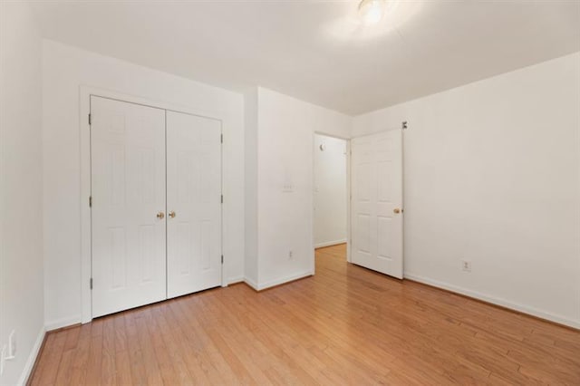 unfurnished bedroom featuring light hardwood / wood-style flooring and a closet