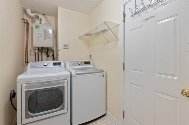 clothes washing area with tankless water heater and washing machine and clothes dryer