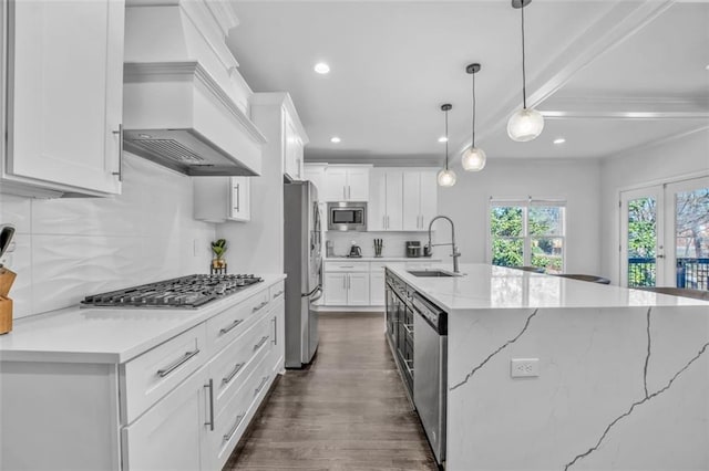 kitchen with appliances with stainless steel finishes, white cabinetry, a sink, and custom exhaust hood