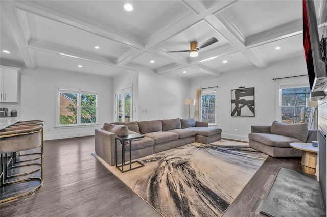 living area featuring coffered ceiling, beamed ceiling, baseboards, and wood finished floors